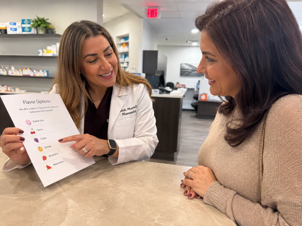 Pharmacist showing a parent flavor options for a compounded medication at the pharmacy counter
